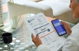 a senior woman pays her utility bills through the banking app on her phone.