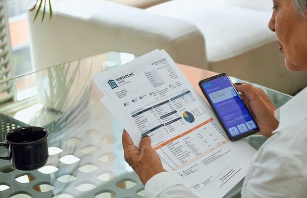 a senior woman pays her utility bills through the banking app on her phone.