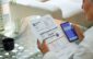 a senior woman pays her utility bills through the banking app on her phone.